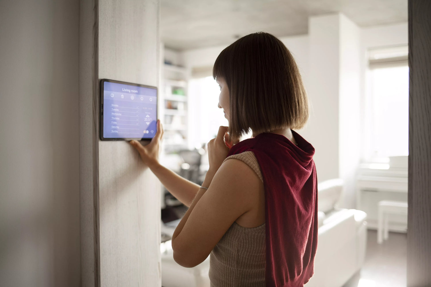 Femme vérifiant la qualité de l'air avec un capteur CO2 à la maison